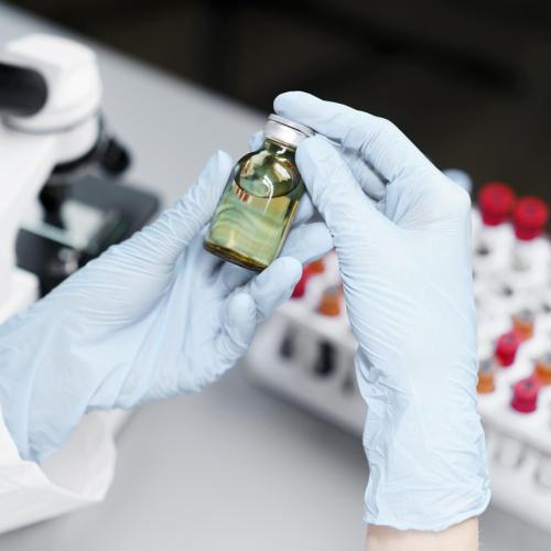 high-angle-female-researcher-laboratory-with-vaccine-bottle